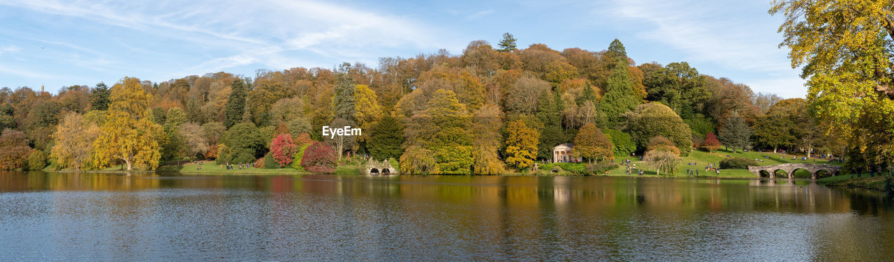 Panoramic photo of the autumn colours around the lake at stourhead gardens in wiltshire.