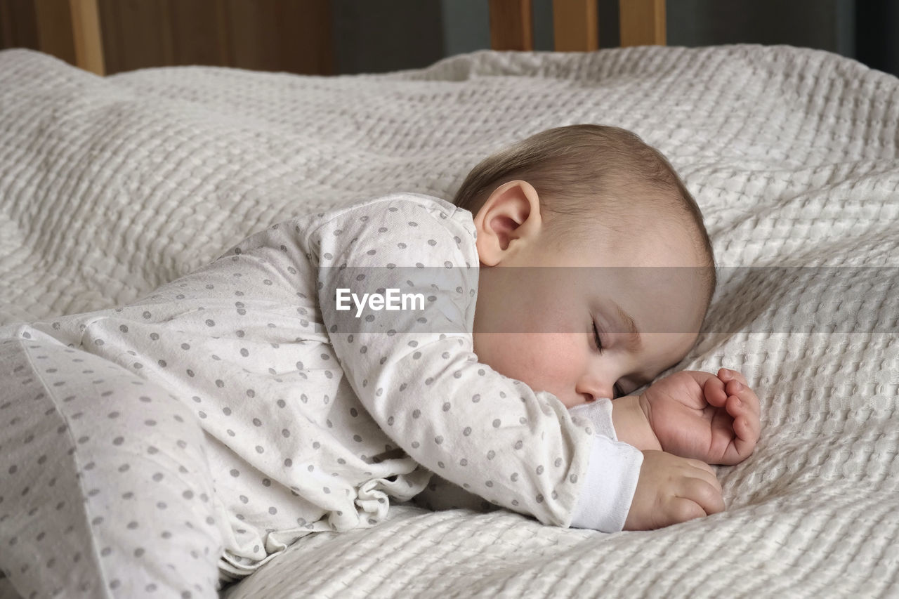 Peaceful adorable baby sleeping on his bed at home. sleeping newborn baby concept. one year old baby