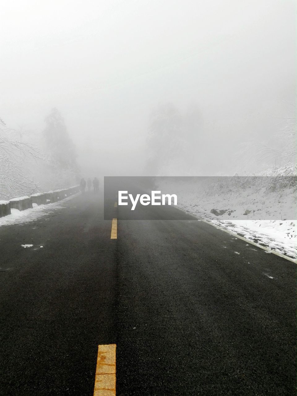 Road in foggy weather against sky during winter