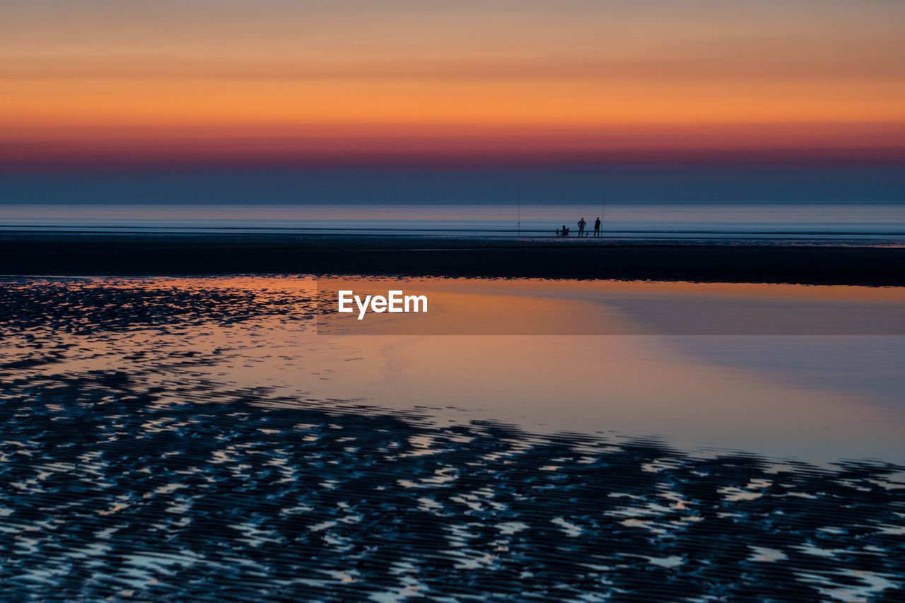 Scenic view of sea against orange sky