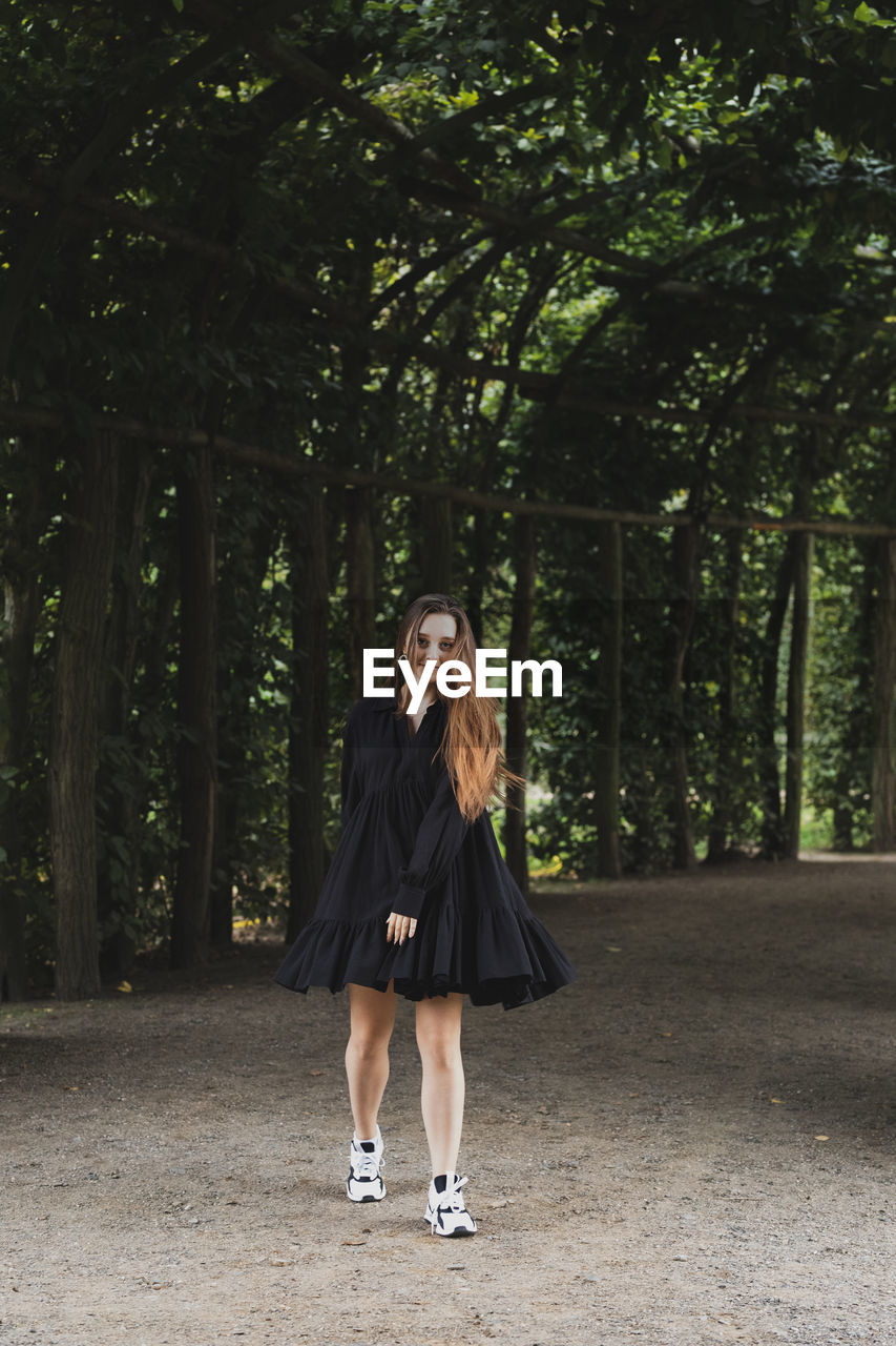 Full length of woman standing in forest