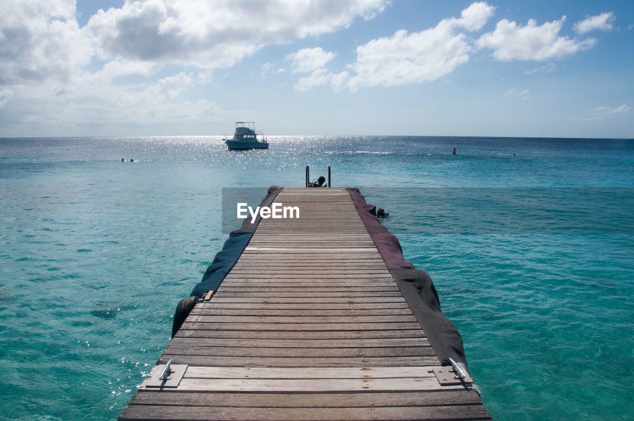 water, sea, sky, horizon, cloud, ocean, pier, scenics - nature, horizon over water, nature, beauty in nature, land, beach, tranquility, jetty, shore, nautical vessel, tranquil scene, holiday, vacation, travel, trip, wood, travel destinations, transportation, blue, coast, idyllic, the way forward, seascape, day, tourism, outdoors, architecture, summer, environment, relaxation, tropical climate, urban skyline, no people, sunlight, island, non-urban scene, landscape, bay, body of water, vehicle, wave, turquoise colored, boardwalk