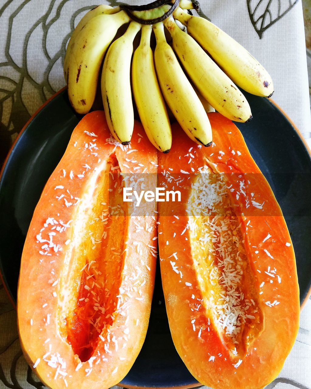 High angle view of bananas and halved papaya on table