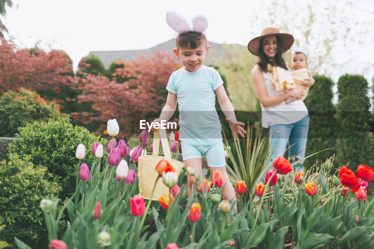 Smiling woman looking at son playing in garden