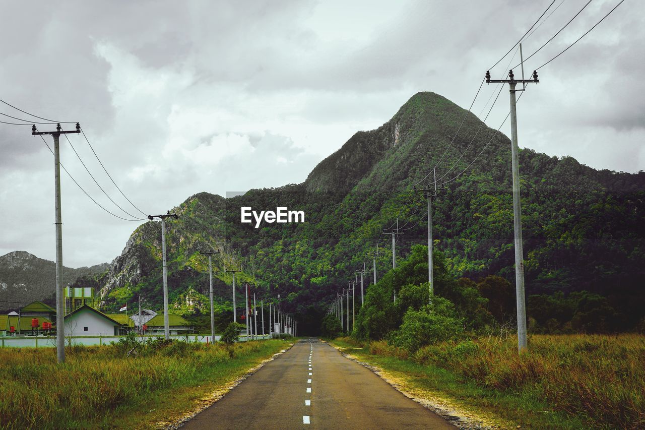 Road amidst plants and mountains against sky