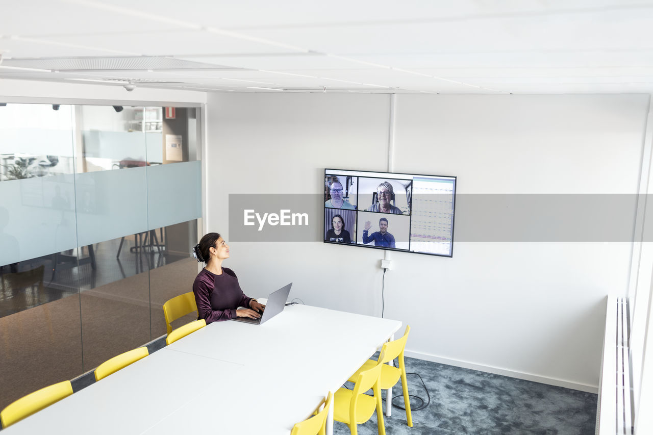 Woman in boardroom having video conference