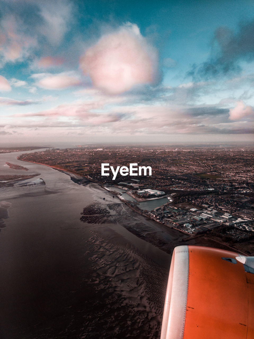 Aerial view of cityscape against sky with jet engine