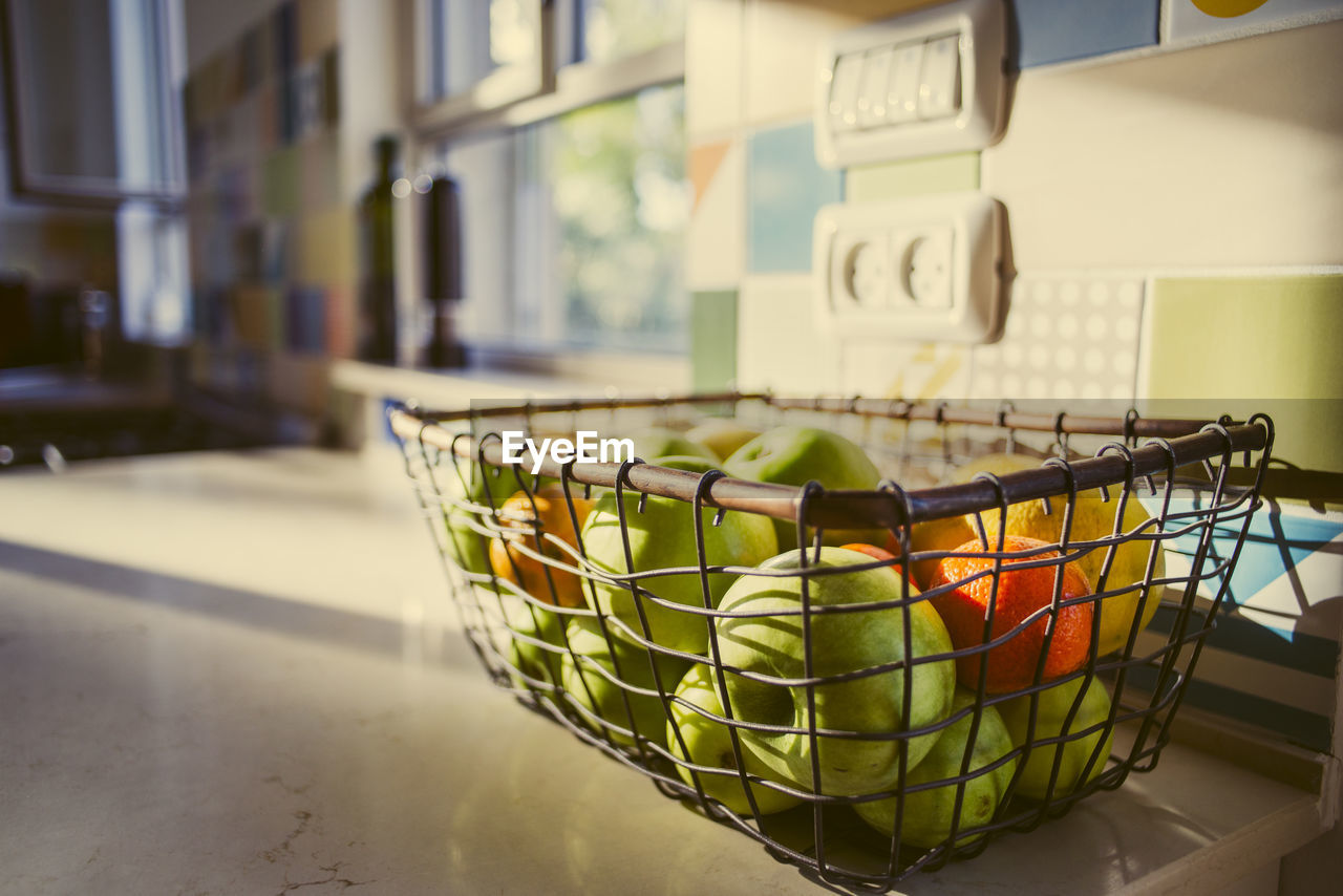 Close-up of fruits in basket on table at home