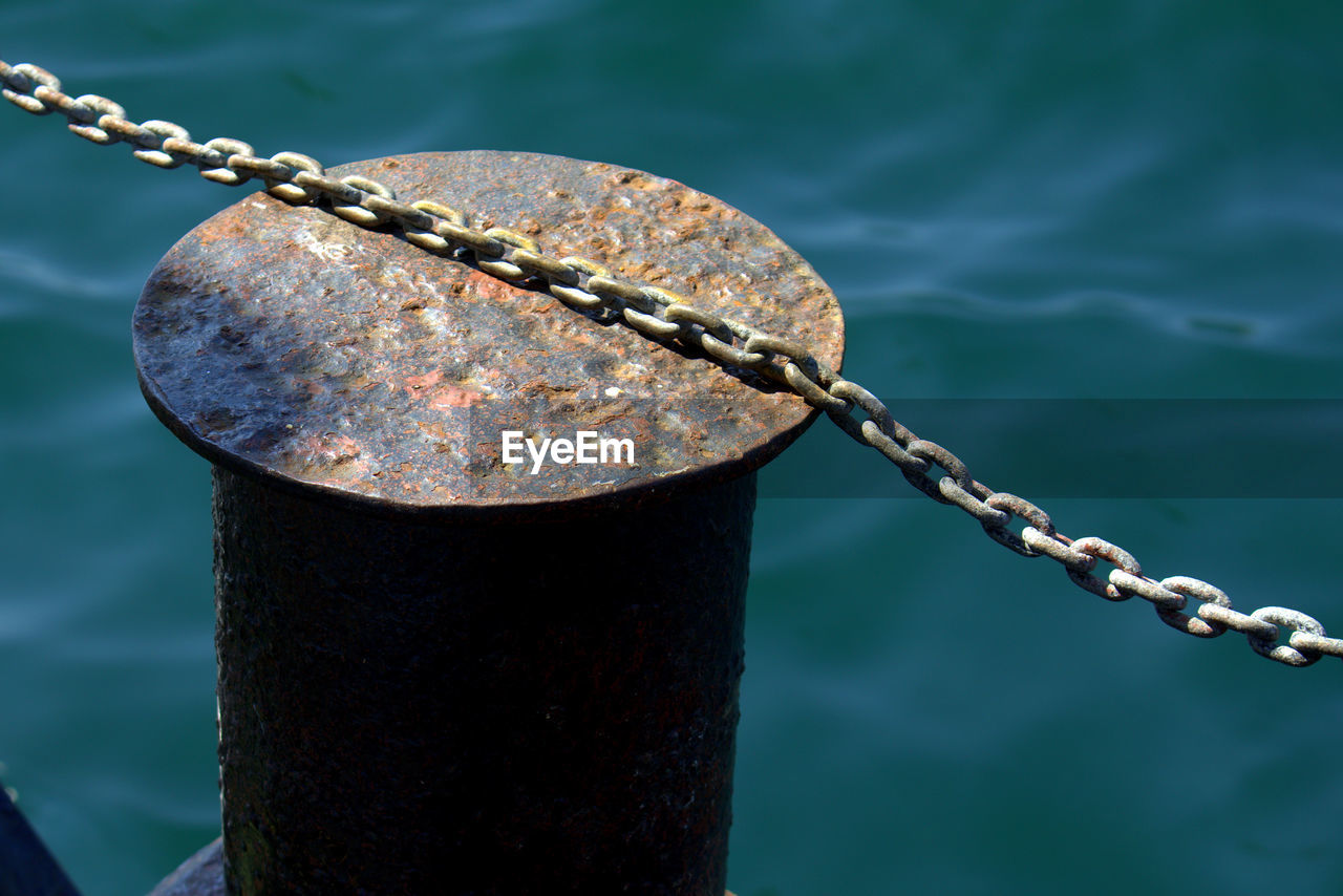 Close-up of bollard against rippled water