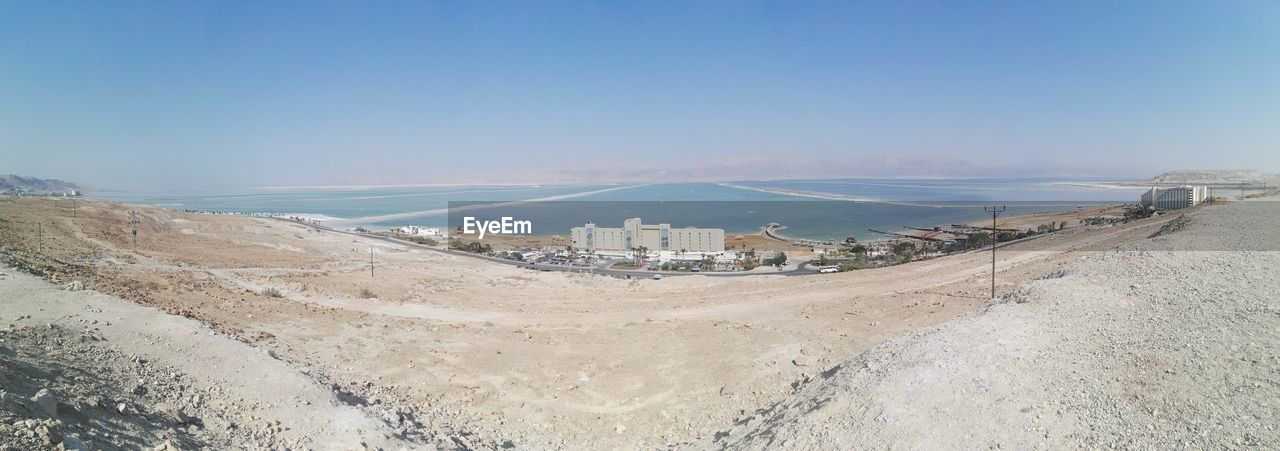 Scenic view of desert by dead sea against sky