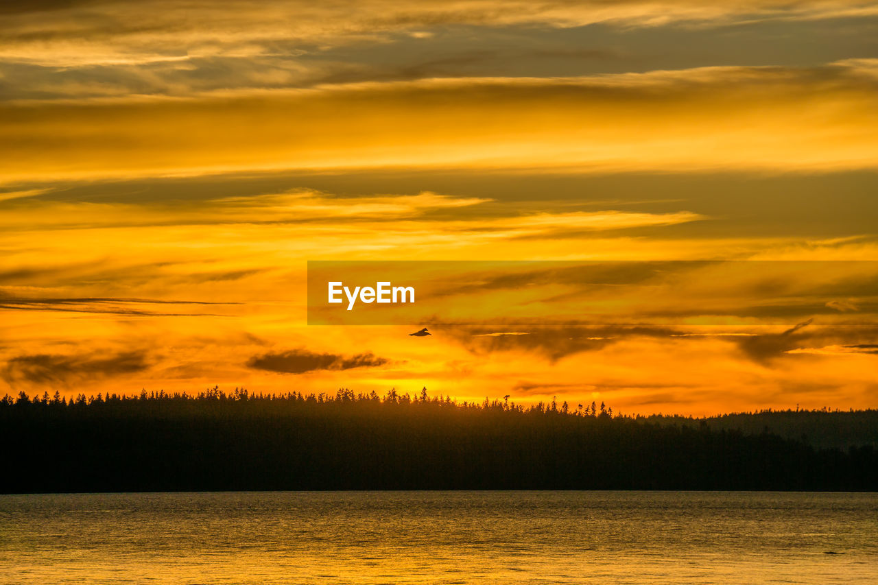 Scenic view of lake against orange sky