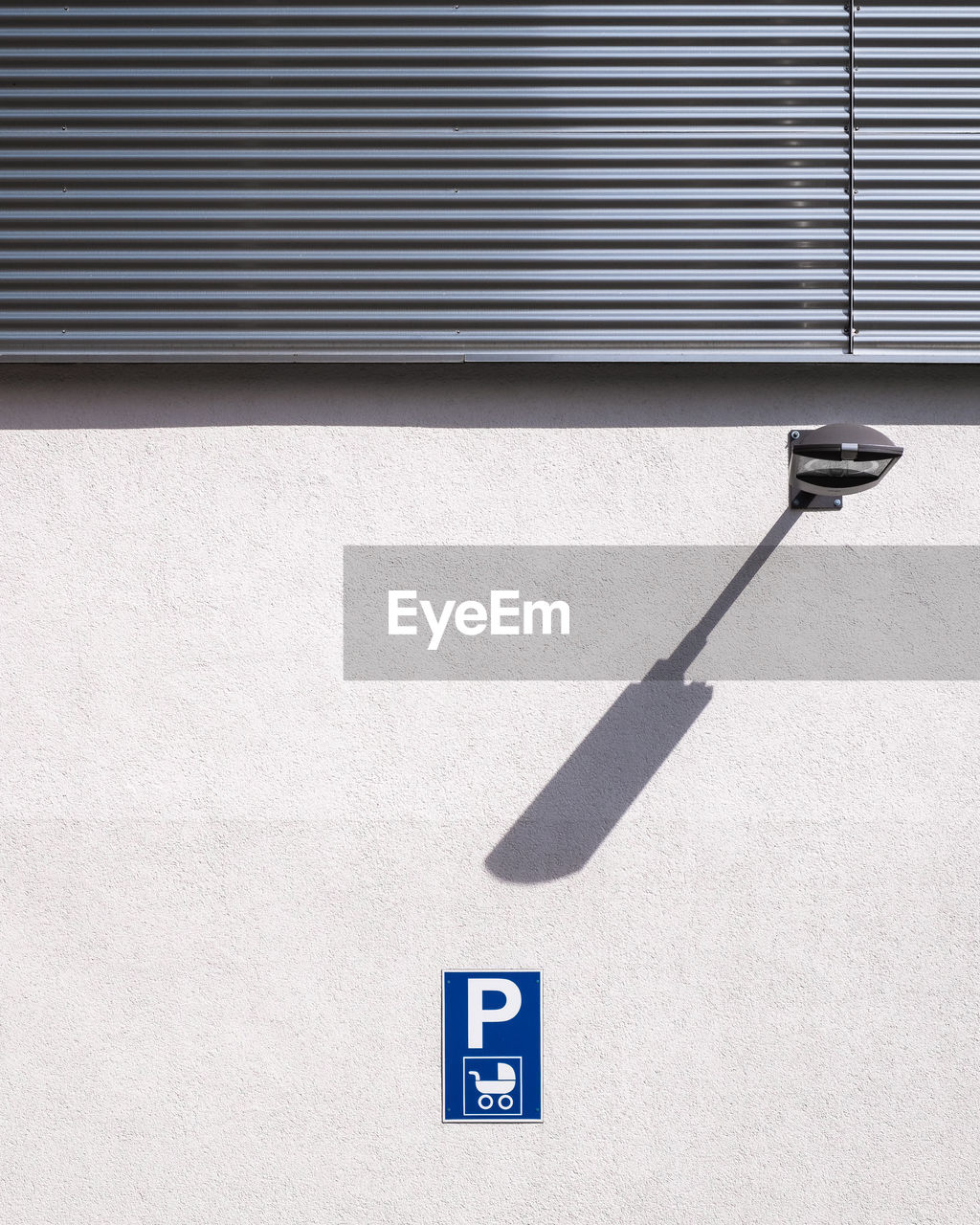 Parking sign on wall during sunny day