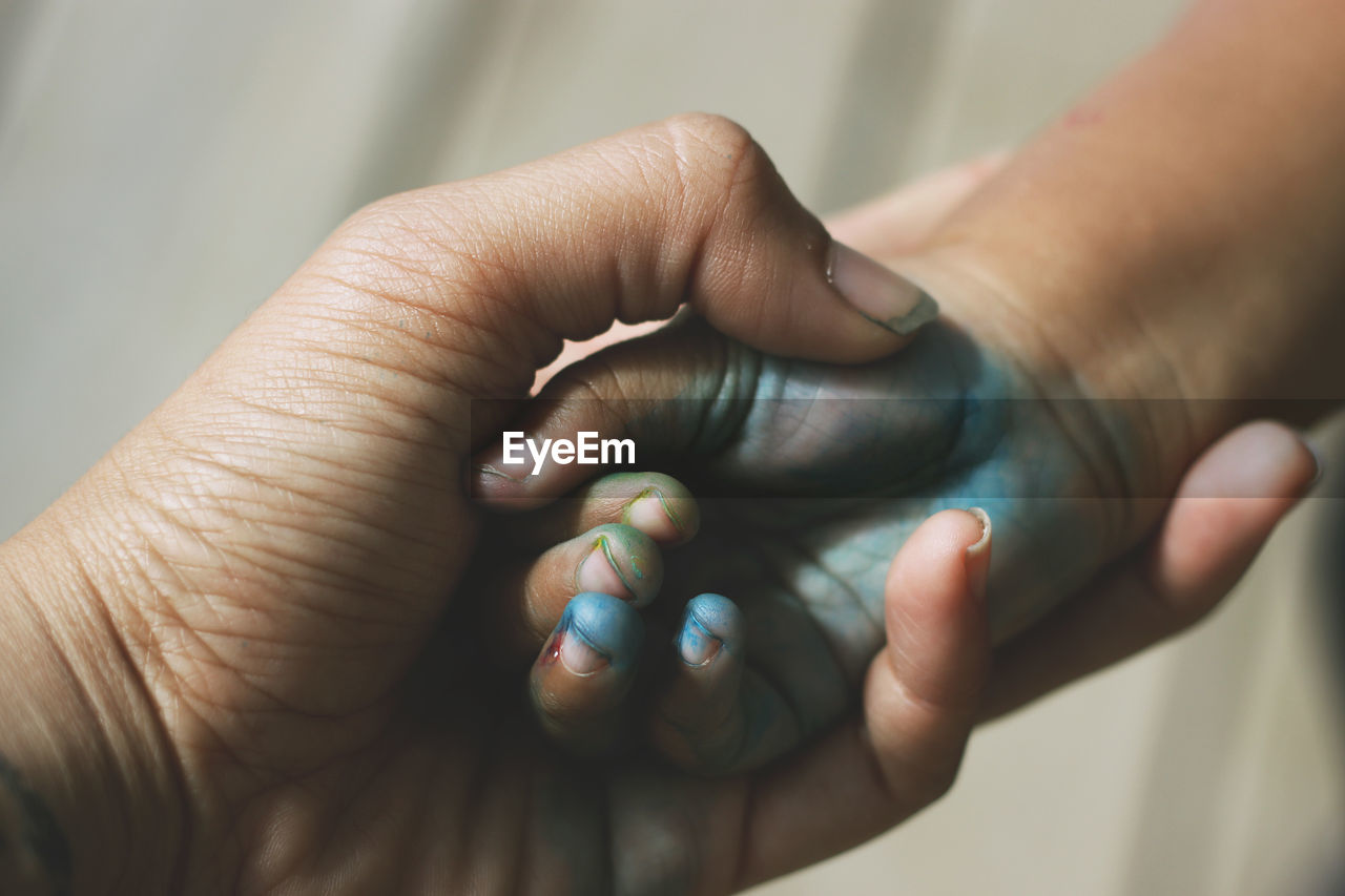 Cropped image of person holding messy hand on child