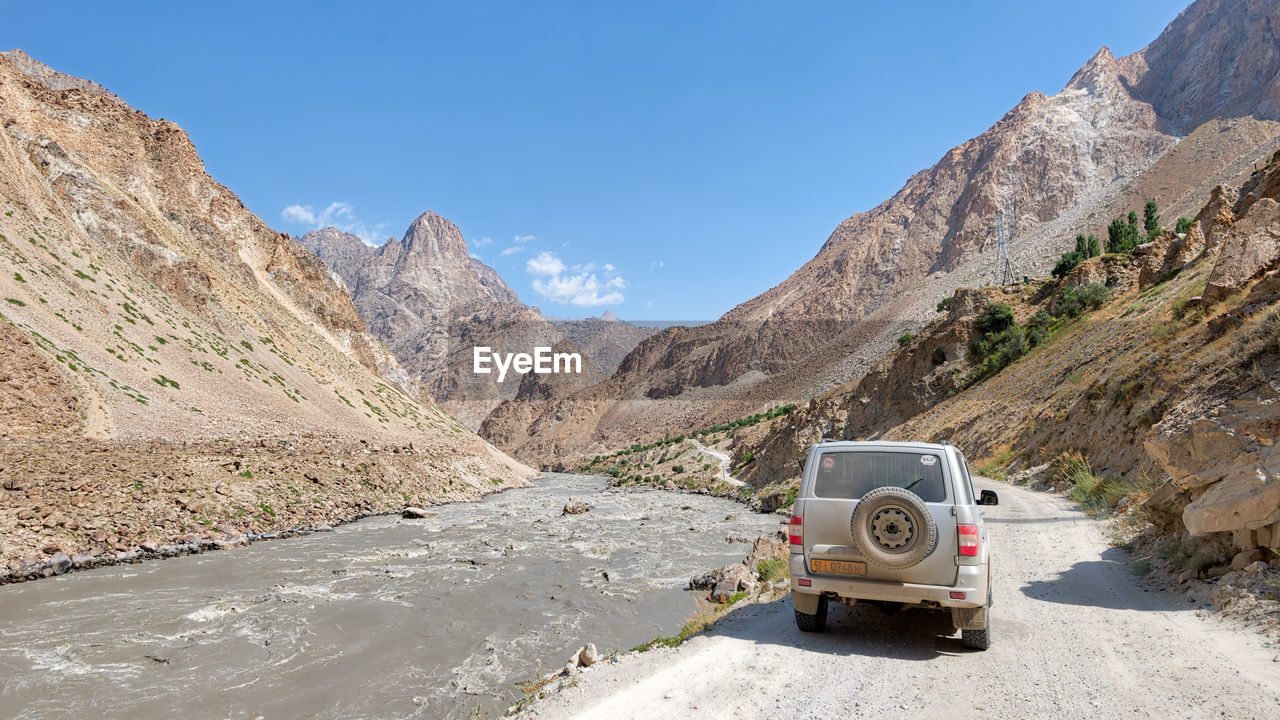 ROAD BY MOUNTAINS AGAINST SKY