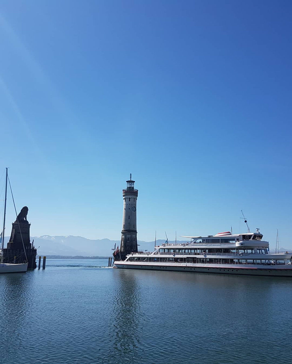 water, architecture, lighthouse, nautical vessel, transportation, sky, sea, built structure, vehicle, nature, building exterior, tower, blue, travel, harbor, building, mode of transportation, ship, travel destinations, no people, channel, guidance, clear sky, craft, bay, copy space, city, ocean, watercraft, pier, outdoors, day, tourism, sailing, landscape, environment, tranquility