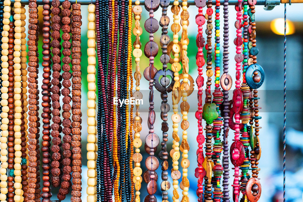 multi colored, necklace, jewelry, bead, fashion accessory, retail, market, for sale, variation, no people, hanging, large group of objects, jewellery, close-up, market stall, pattern, bracelet, retail display, full frame, abundance, art, backgrounds, store, fashion, sale, day, chain, small business, business, textile, craft, in a row, side by side, indoors