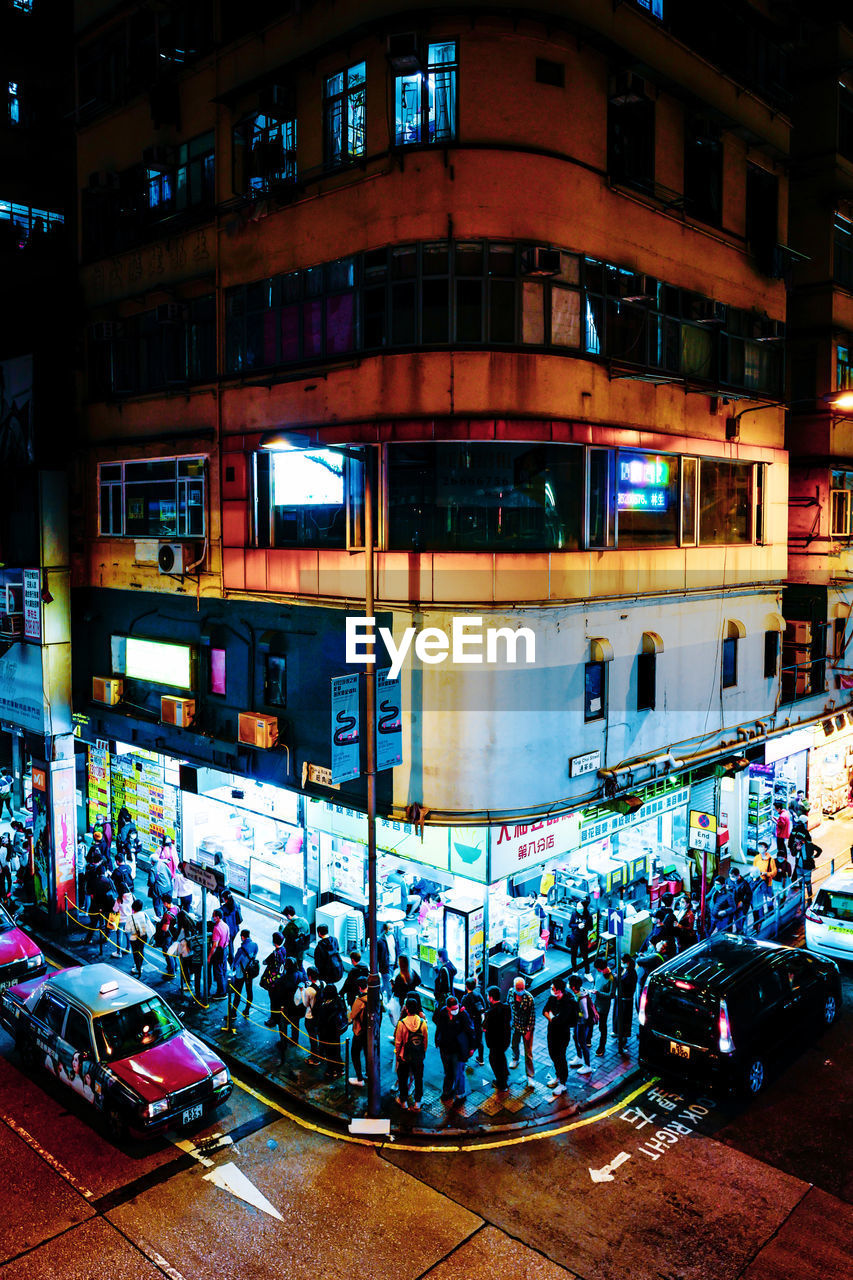 GROUP OF PEOPLE IN CITY STREET AT NIGHT