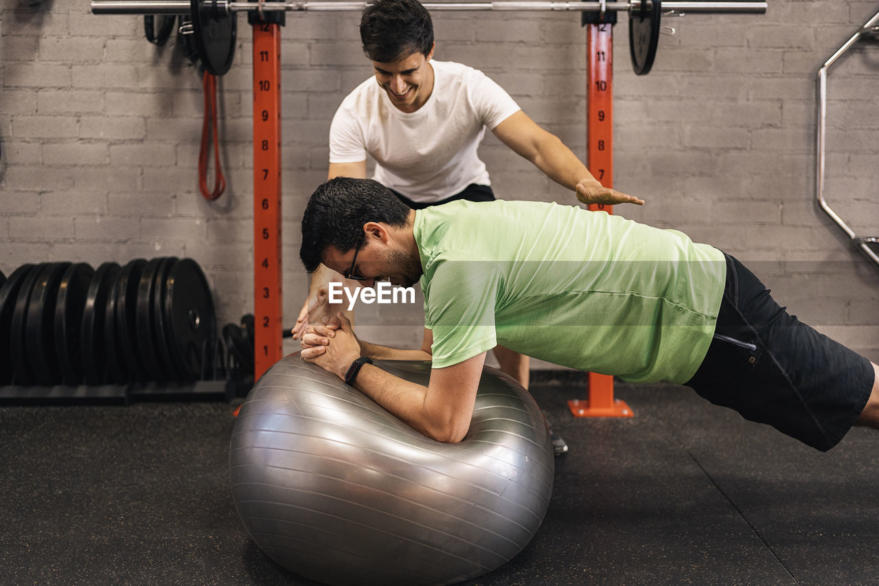 Personal trainer correcting habits in the exercise room. personalized individual training