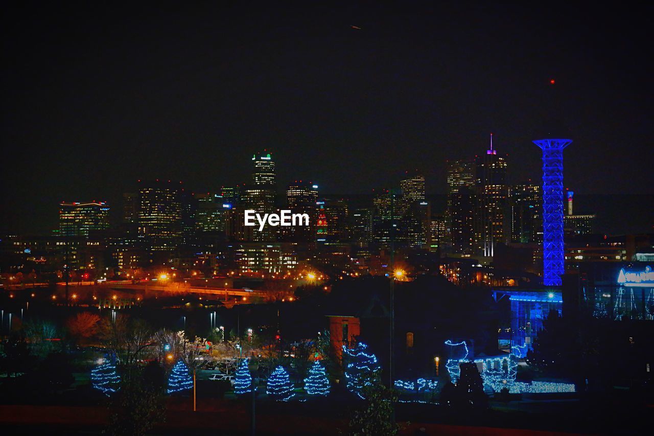 Illuminated cityscape against clear sky at night