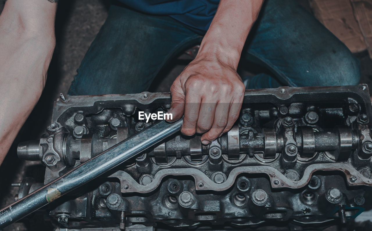 The mechanic is checking the engine.