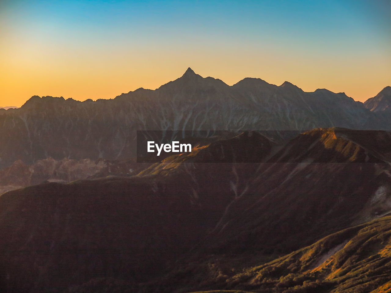 Scenic view of mountains against clear sky during sunset