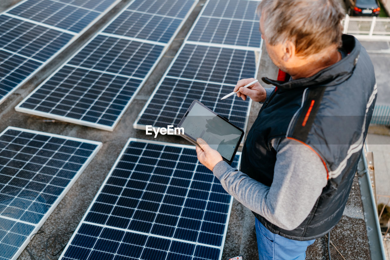 High angle view of engineer inspecting solar panel