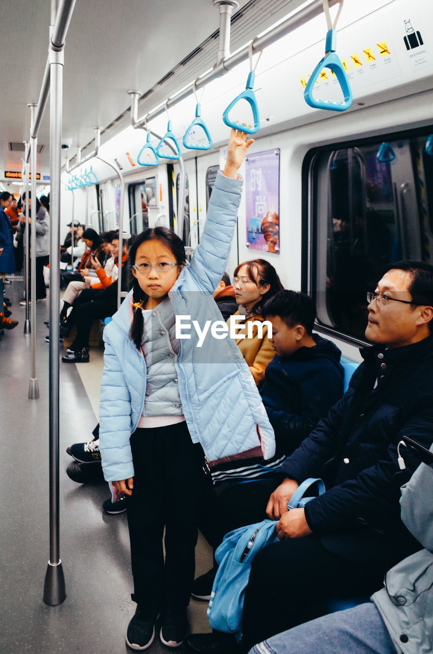 PORTRAIT OF PEOPLE SITTING ON TRAIN