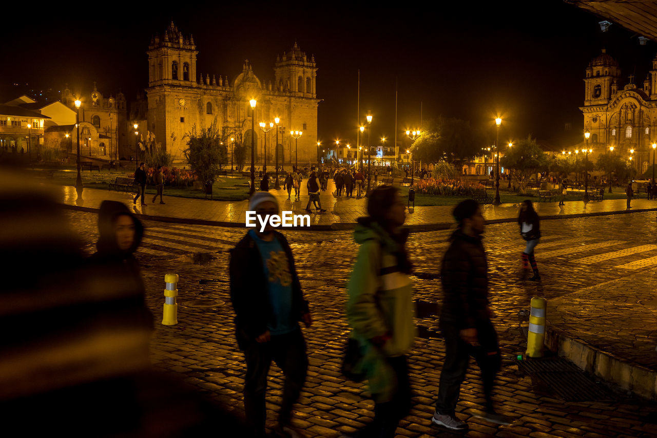 People walking on city street at night