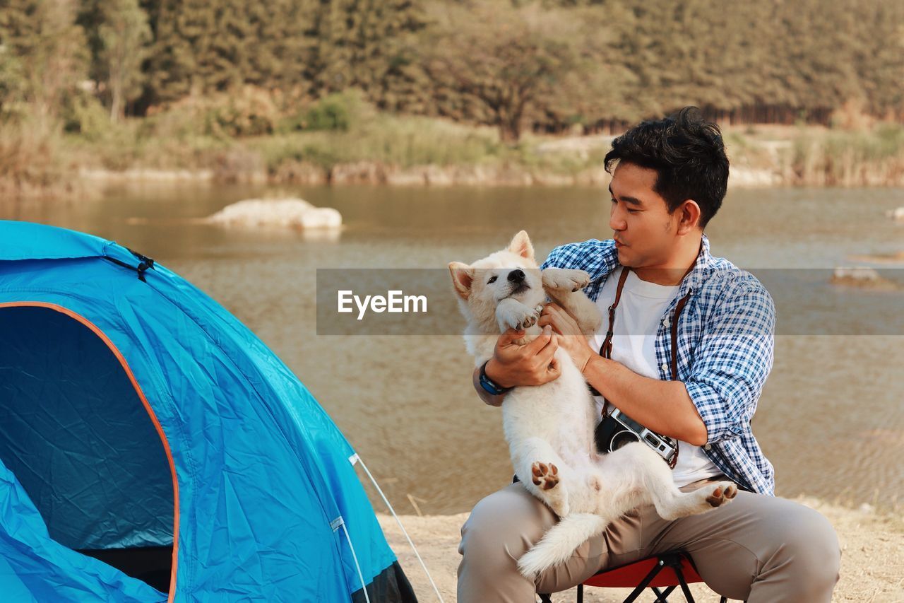 Man with dog on lakeshore at camping