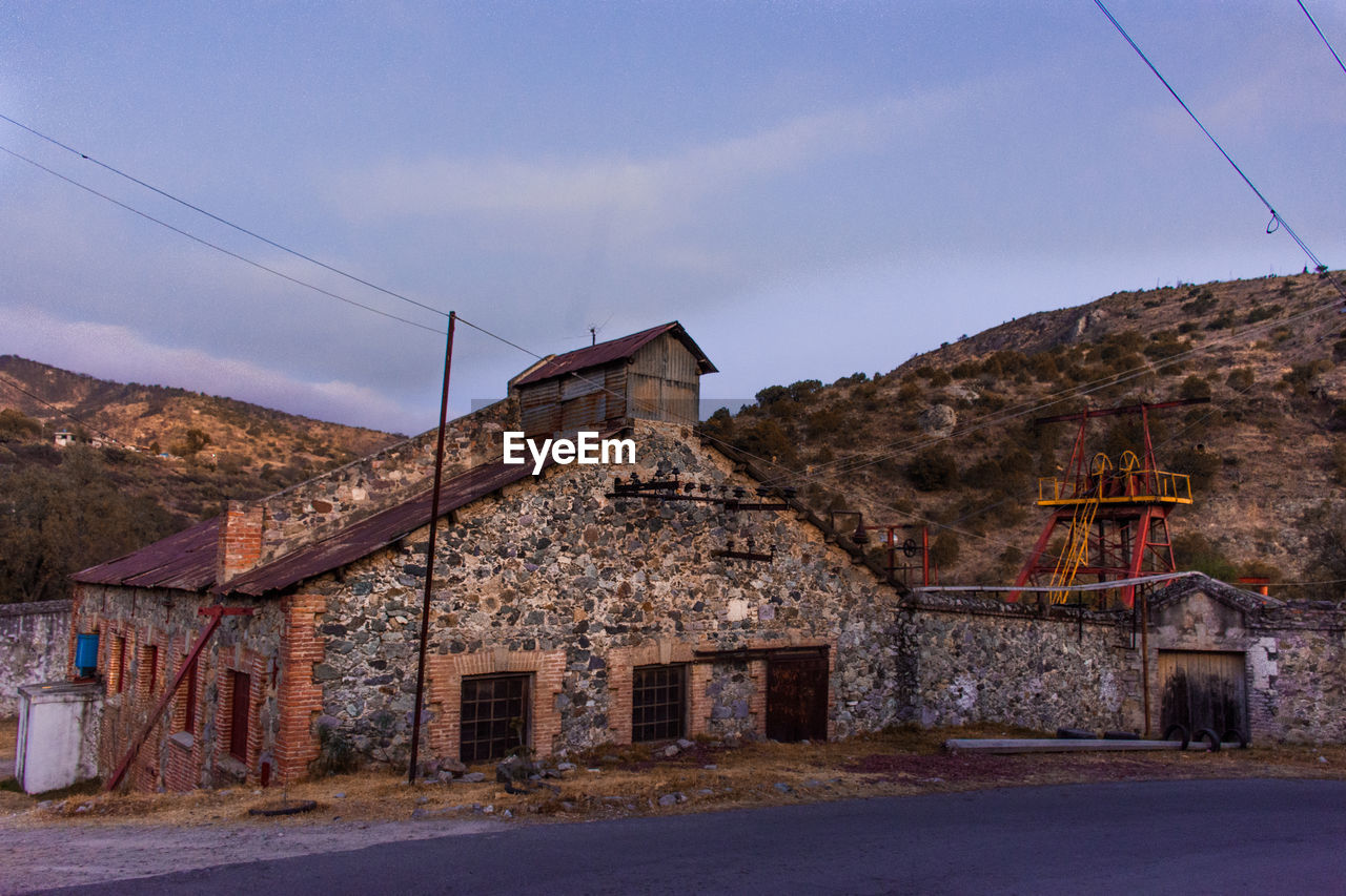 View of historic building by road against sky