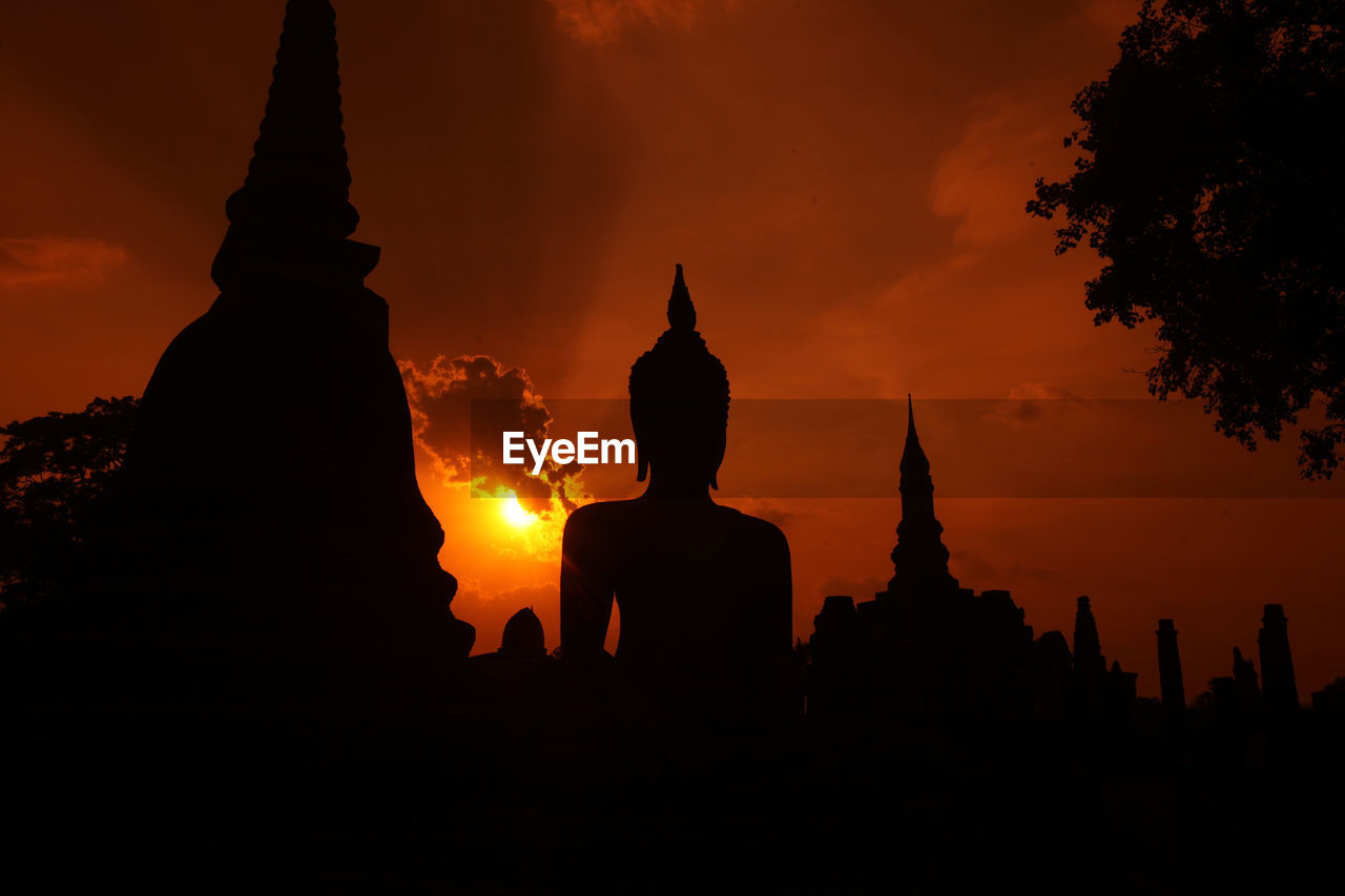 SILHOUETTE OF STATUE AT SUNSET