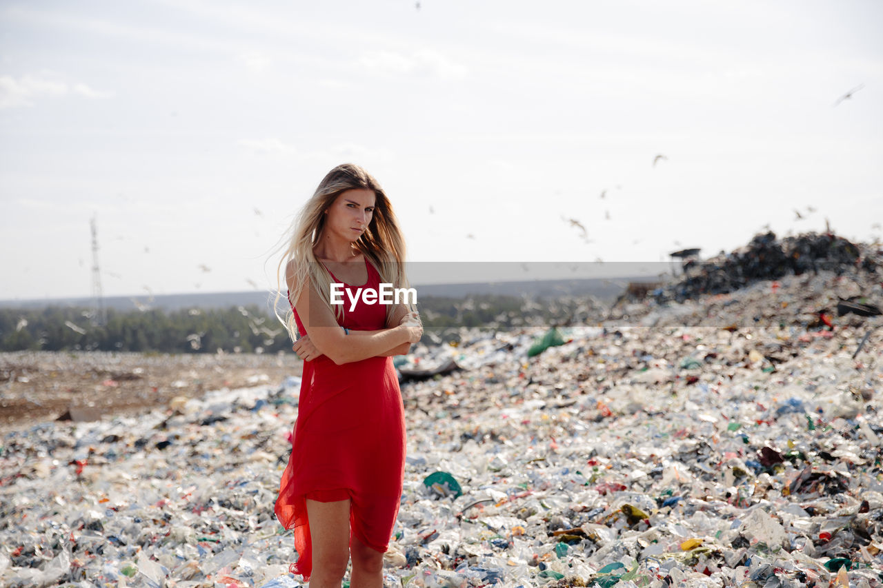 Portrait of young woman walking on garbage