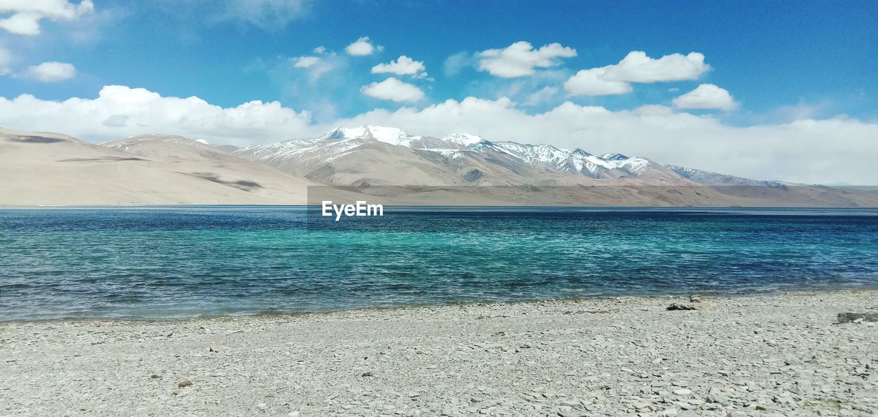 Scenic view of a lake and snowcapped mountains against sky