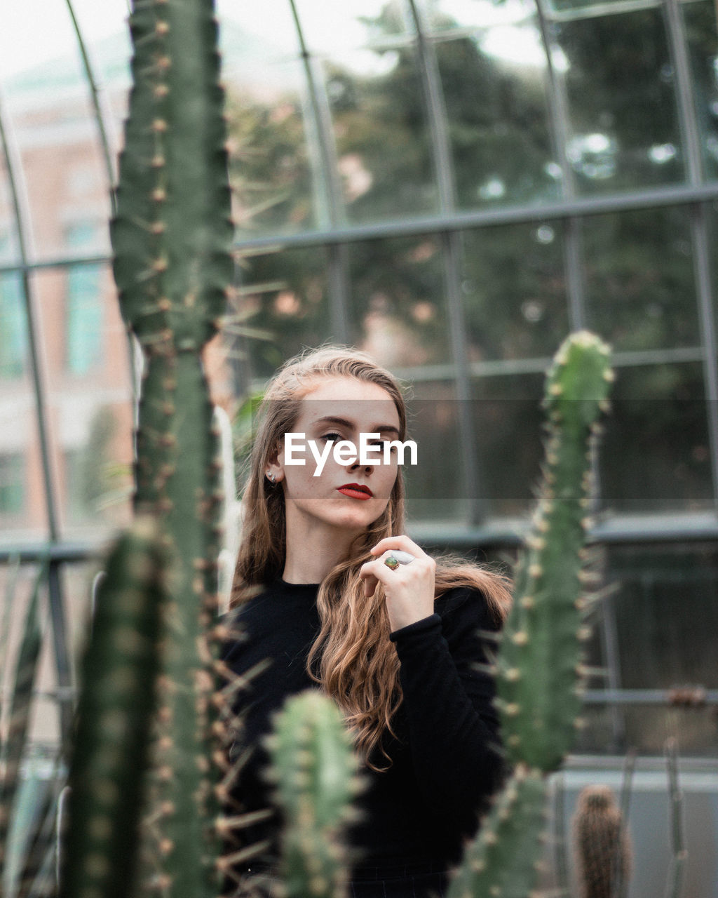 Portrait of young woman against building