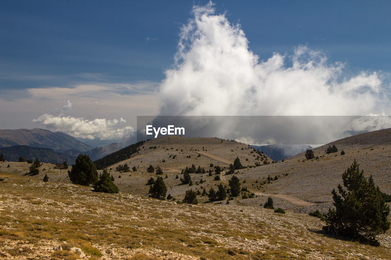 Panoramic view of high landscape with prominent white clouds against sky