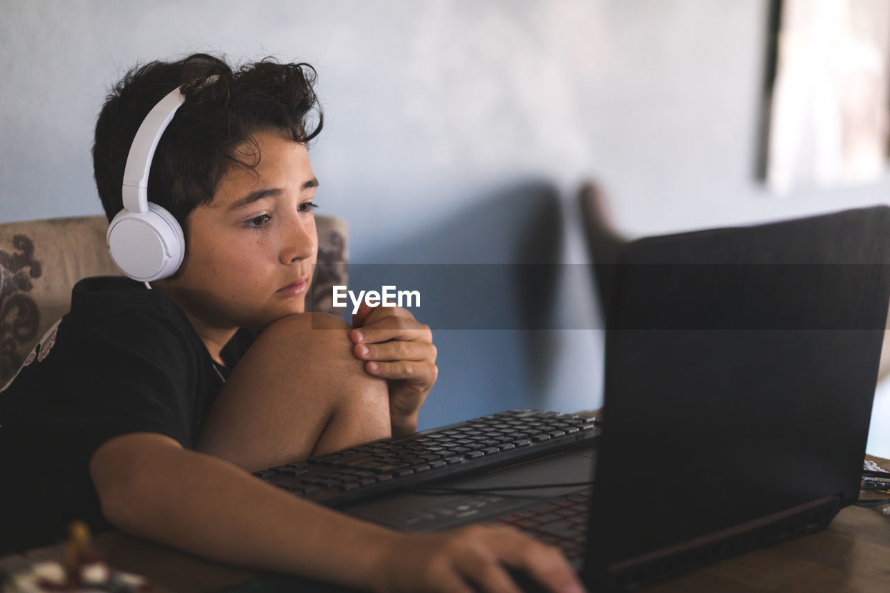 Boy doing his homework on laptop