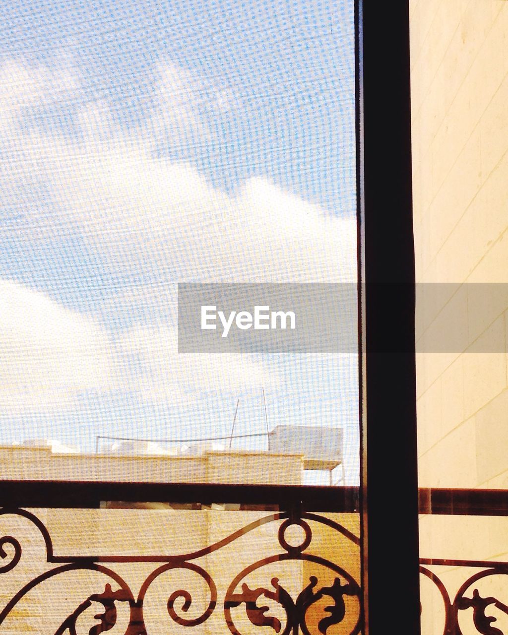 Buildings against sky seen though glass window