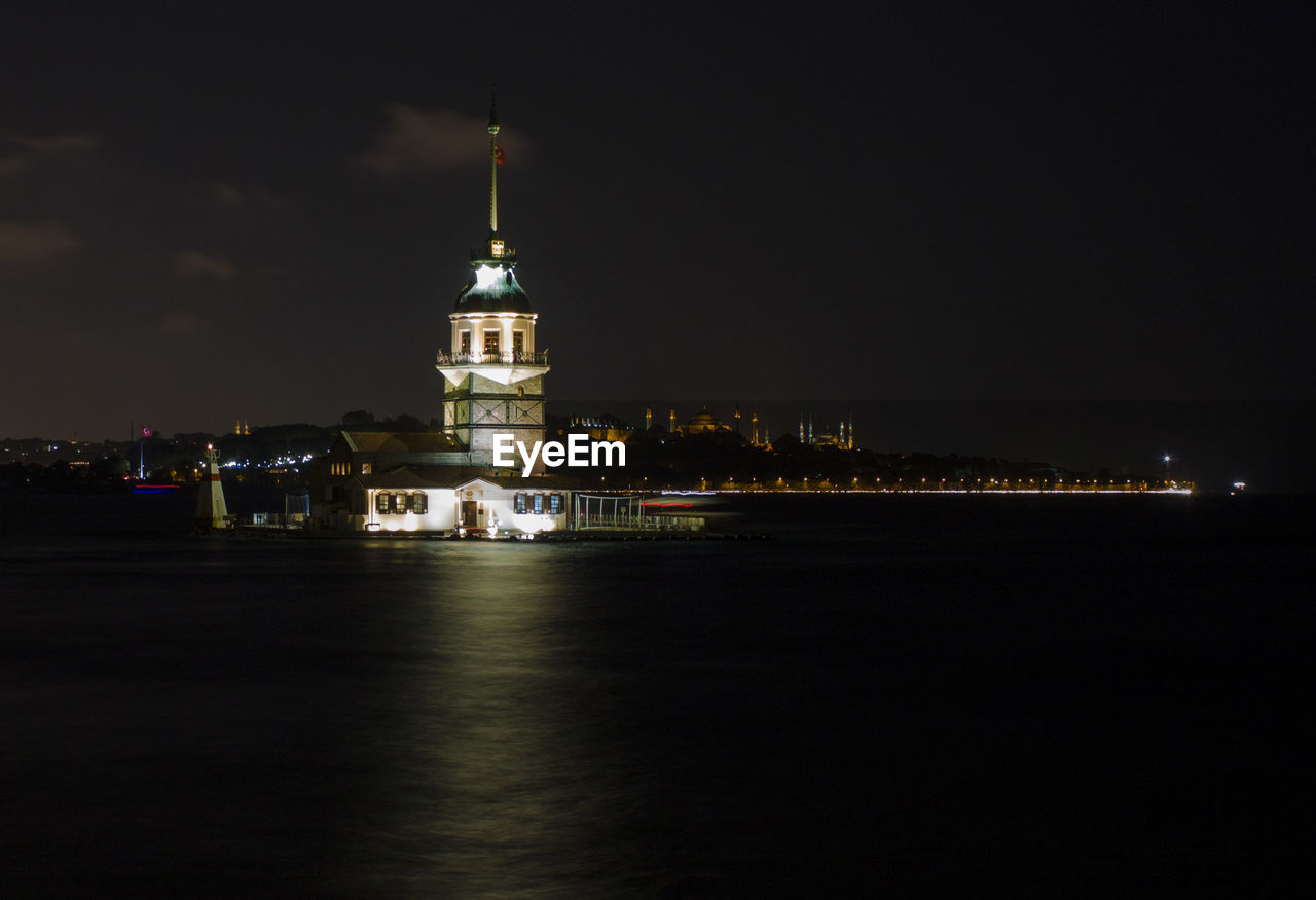 Illuminated buildings against sky at night