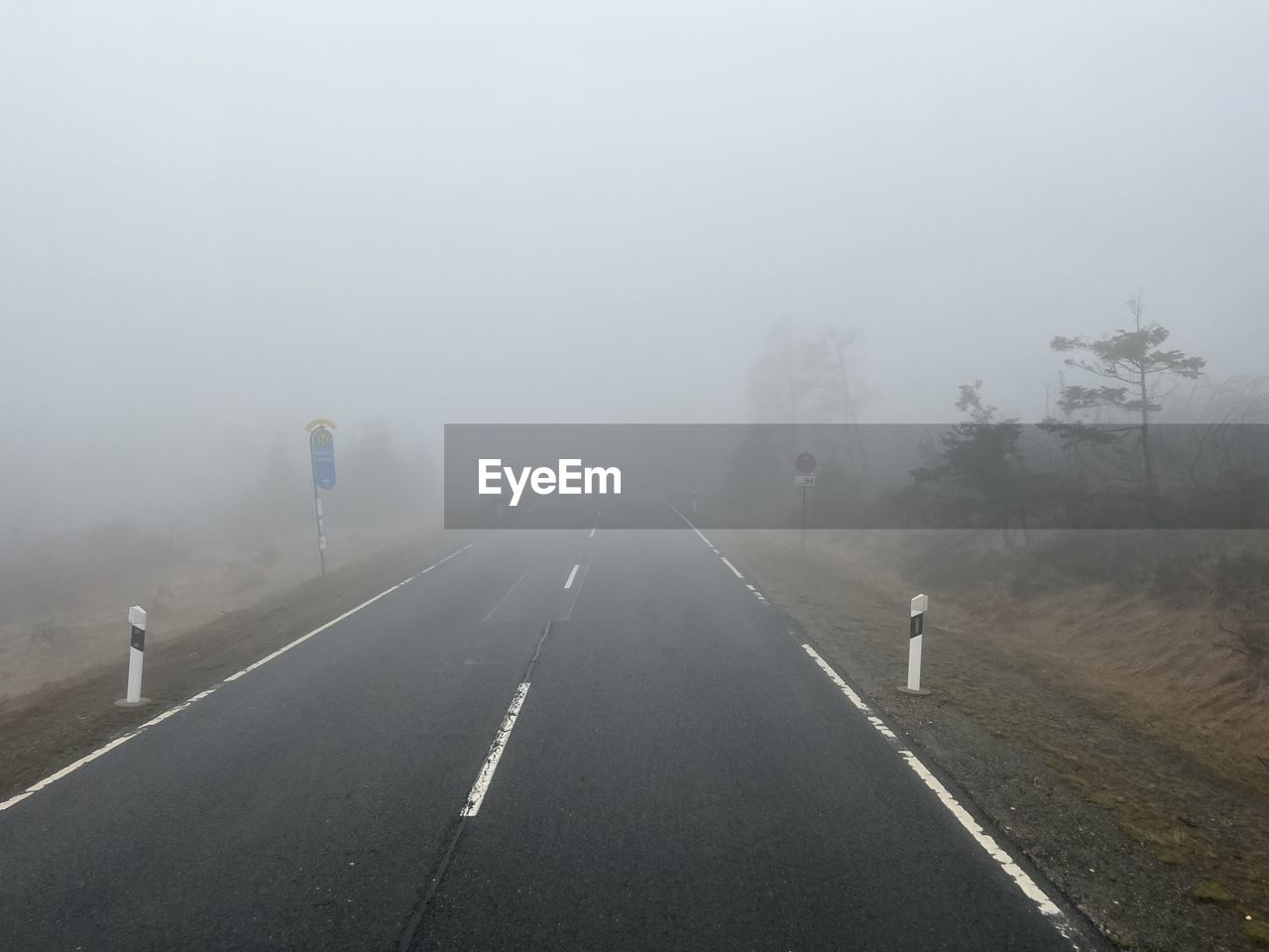 fog, transportation, road, haze, mist, morning, nature, drizzle, sign, environment, symbol, sky, no people, the way forward, travel, mode of transportation, tree, marking, winter, road marking, outdoors, street, cold temperature, day, city, highway, landscape, plant, scenics - nature, land, car, tranquility, beauty in nature, motor vehicle, wet