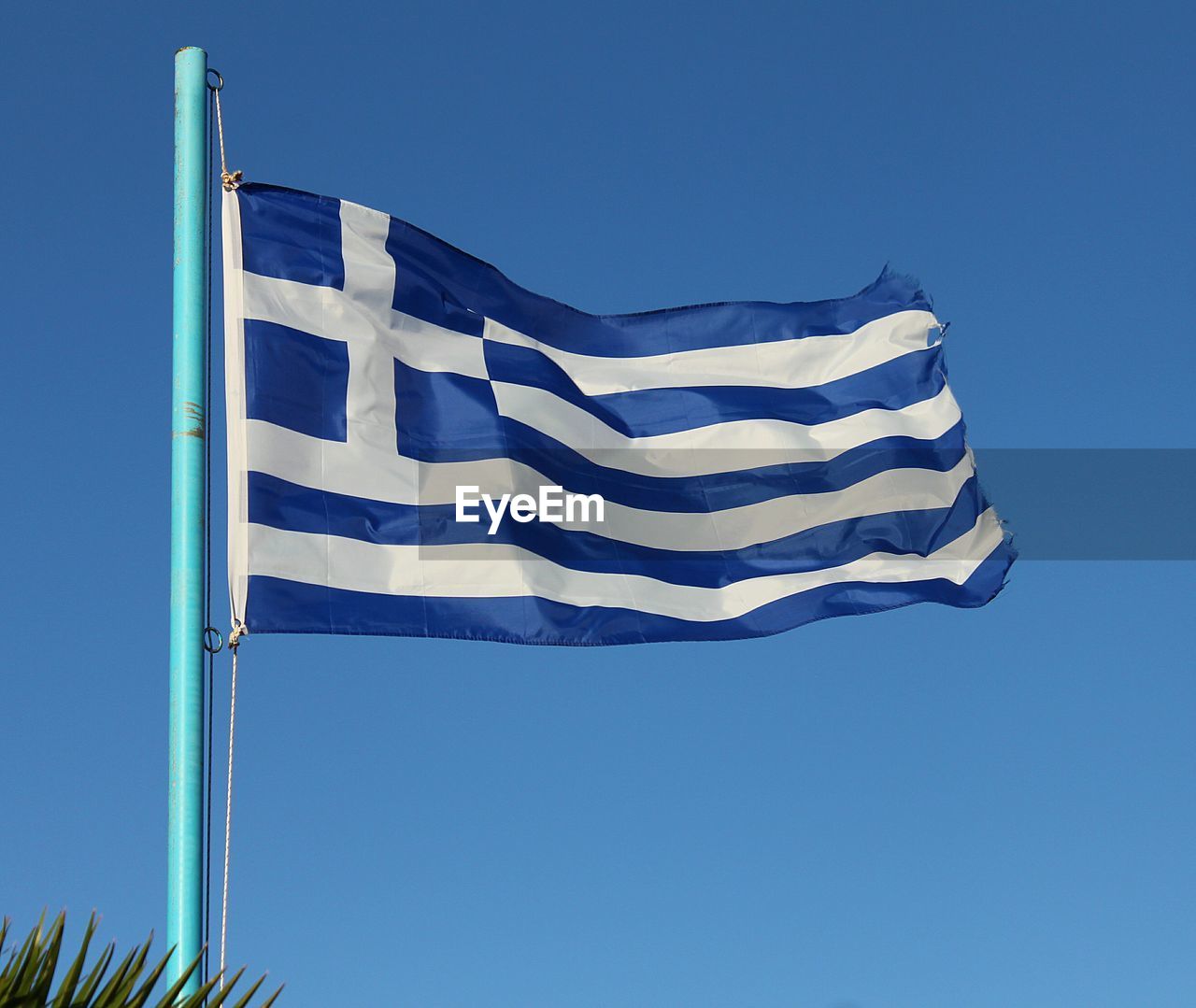 Low angle view of flag against clear blue sky