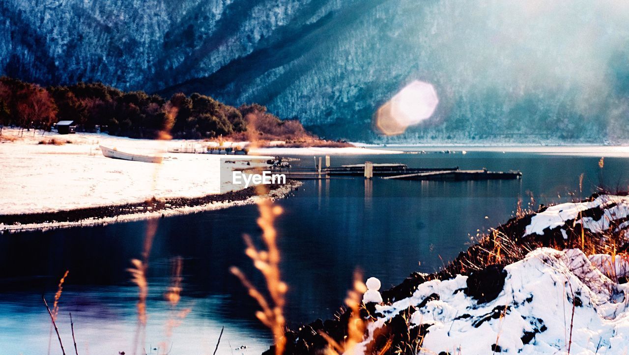SCENIC VIEW OF FROZEN LAKE AGAINST MOUNTAIN