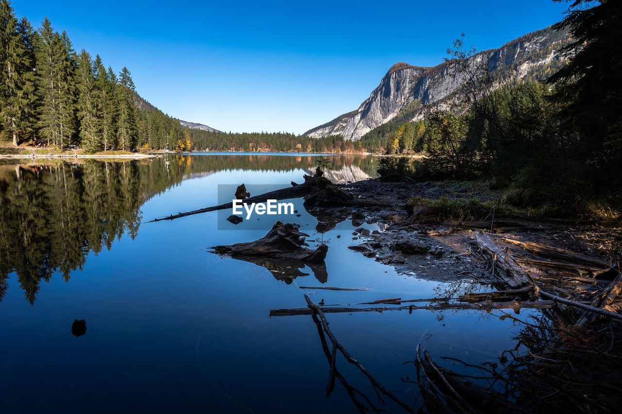 Scenic view of lake and mountains against clear blue sky