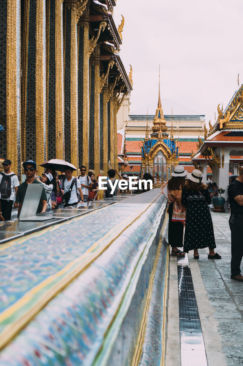 PEOPLE WALKING ON TEMPLE AGAINST BUILDING