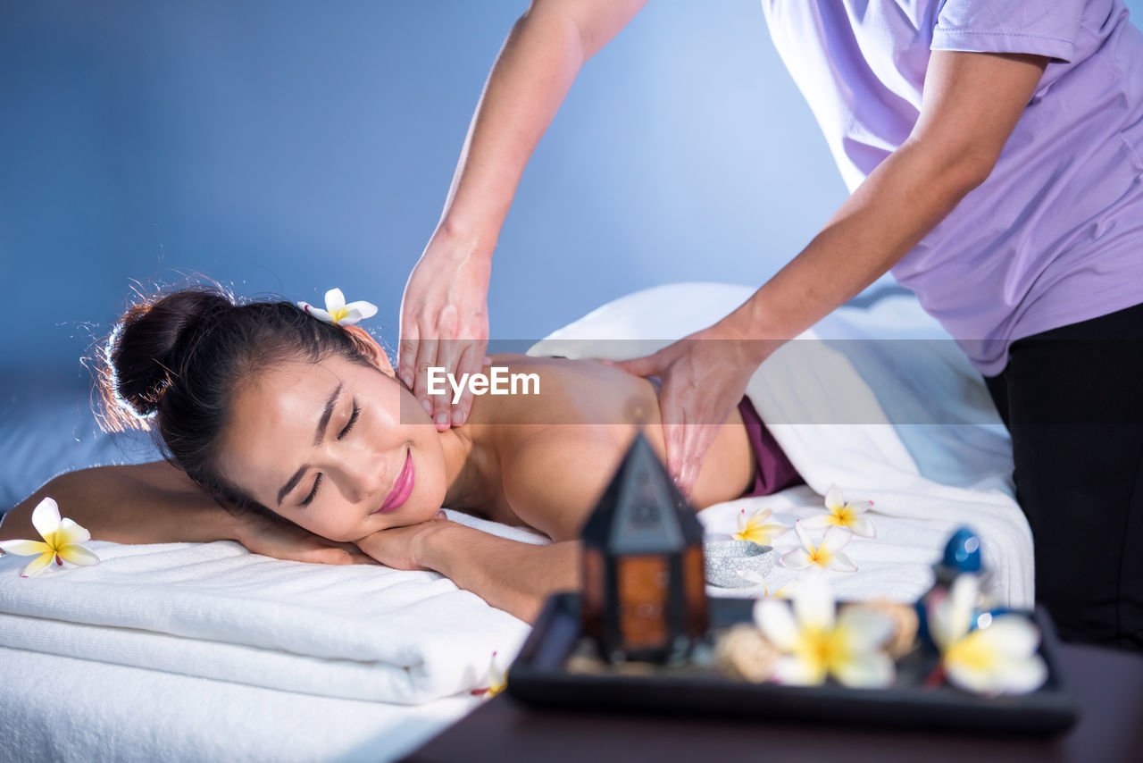 Midsection of woman lying on bed