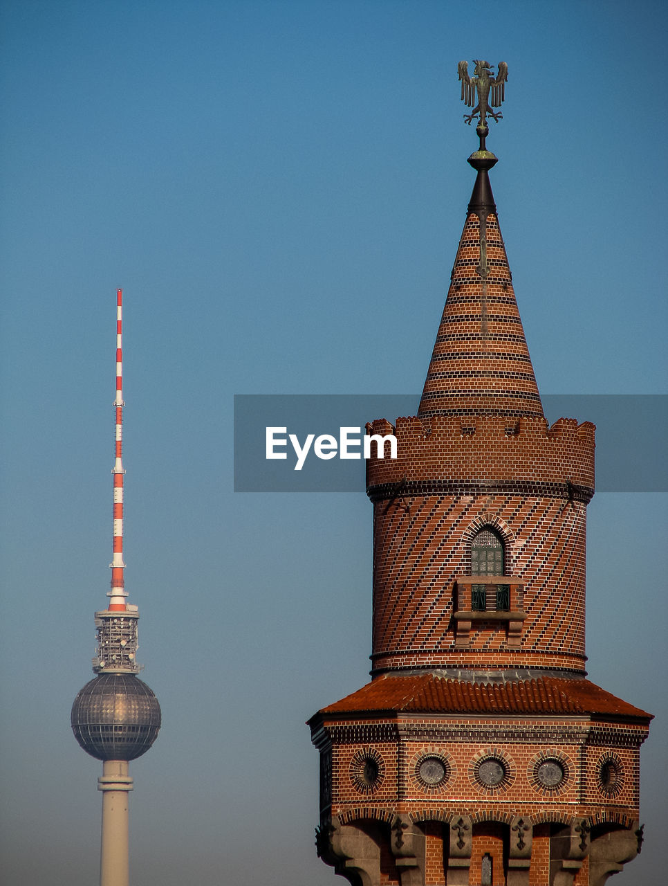 Communications tower in city against clear sky