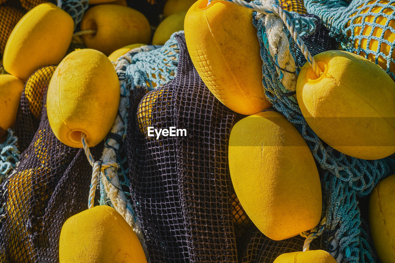 Background of colorful fishing nets with yellow floats, close-up, selective focus. 