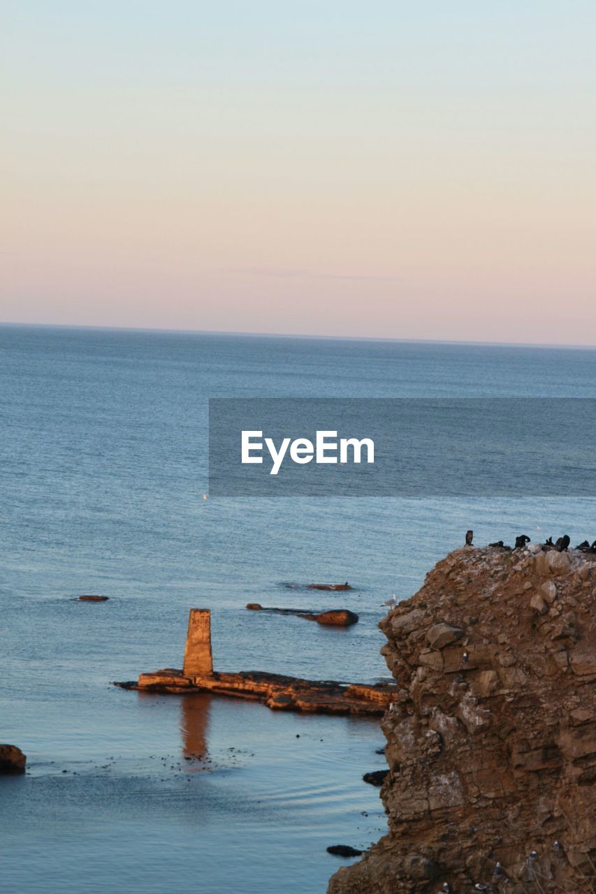 SCENIC VIEW OF SEA WITH ROCKS IN BACKGROUND