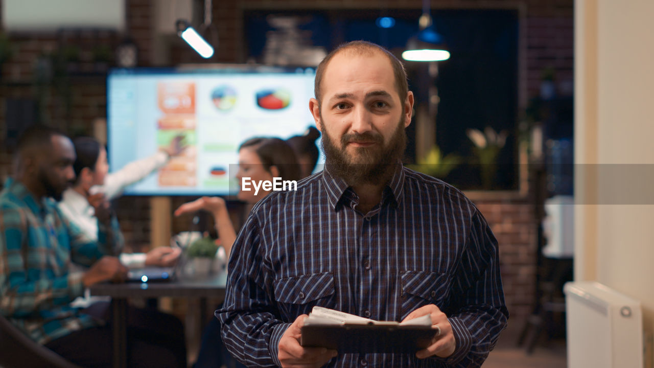 portrait of young man using mobile phone in store