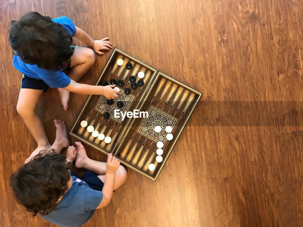 High angle view of brothers playing game on hardwood floor