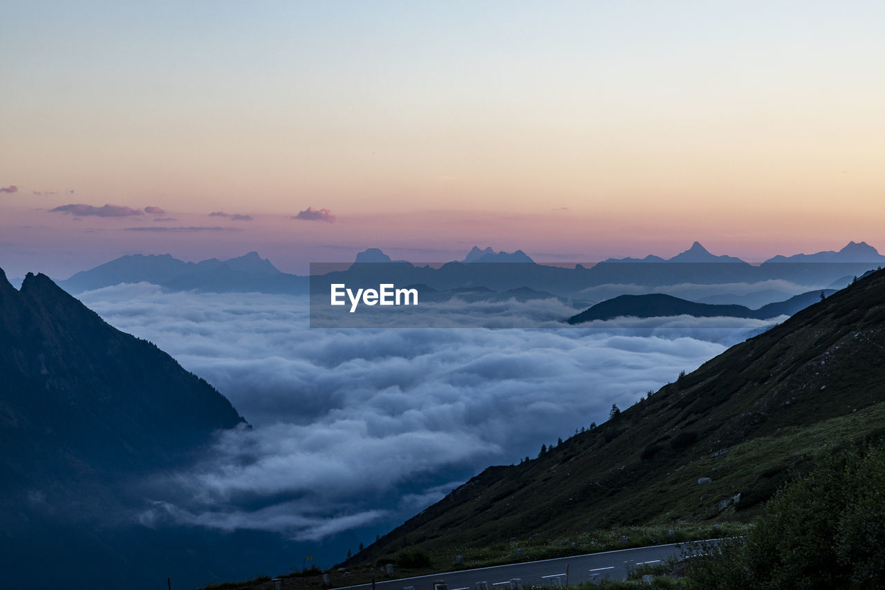 SCENIC VIEW OF MOUNTAINS AGAINST SKY DURING SUNSET